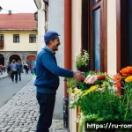 Home 18 루마니아어 기본 회화 - A warm and friendly Romanian street scene during daytime featuring a diverse group of people greetin...